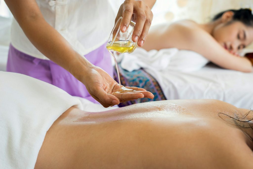 Terapeuta aplicando aceite antes de un masaje